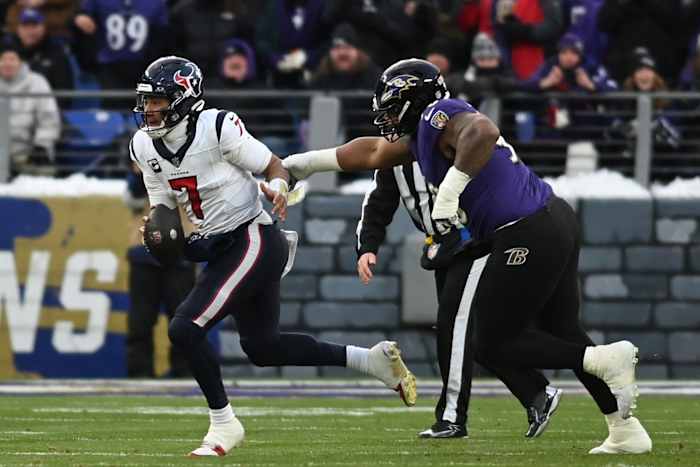Texans quarterback C.J. Stroud runs the ball against Baltimore Ravens defensive tackle Justin Madubuike during the first quarter of a 2024 AFC divisional round game at M&T Bank Stadium.